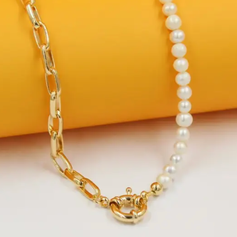 Gold chain and pearl necklace on a yellow background
