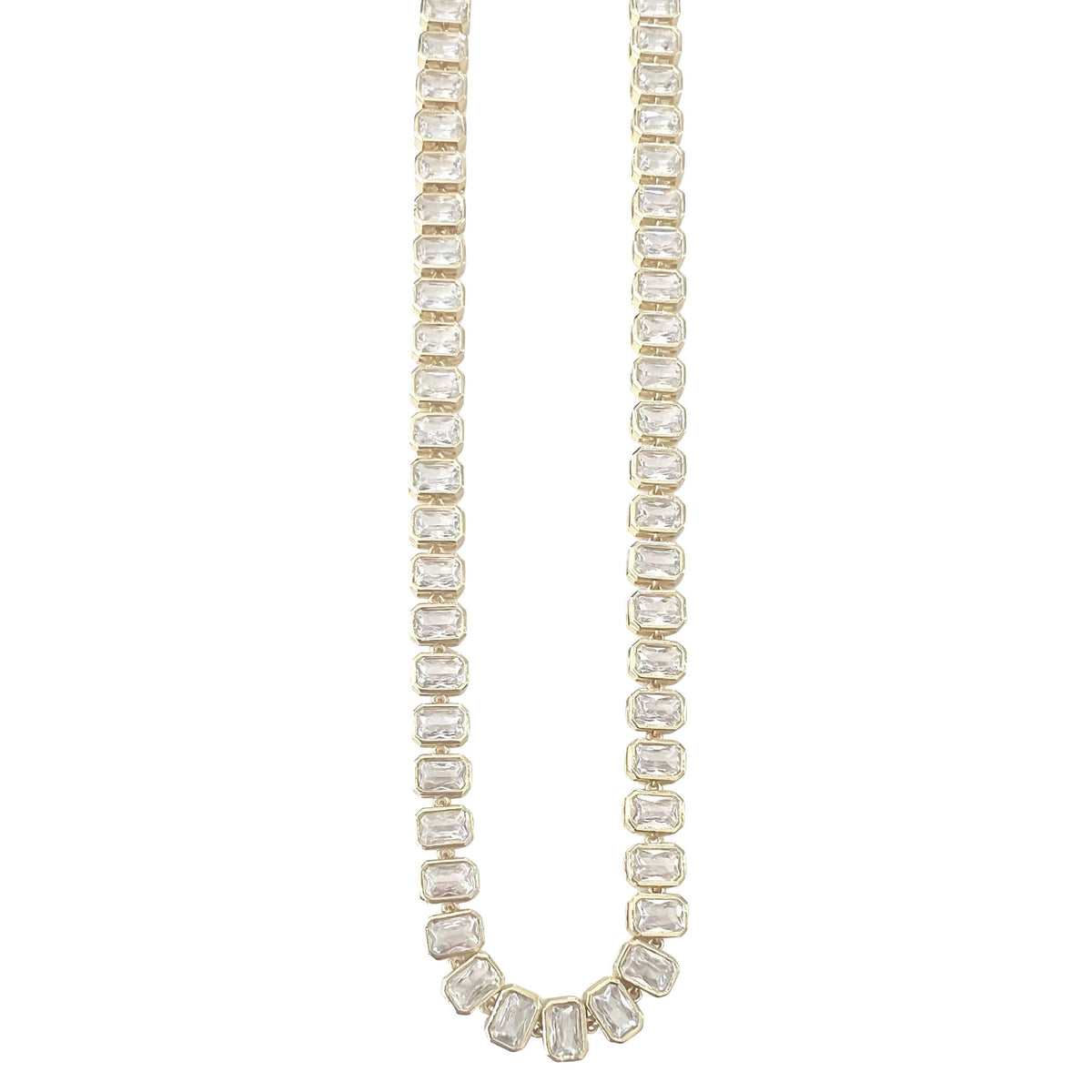 A gold tennis necklace featuring baguette-cut clear stones, shown against a solid white background.