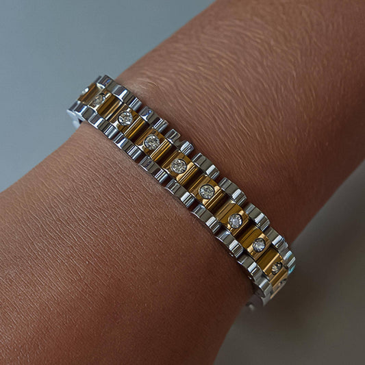 Two-toned bracelet on a wrist with a neutral background