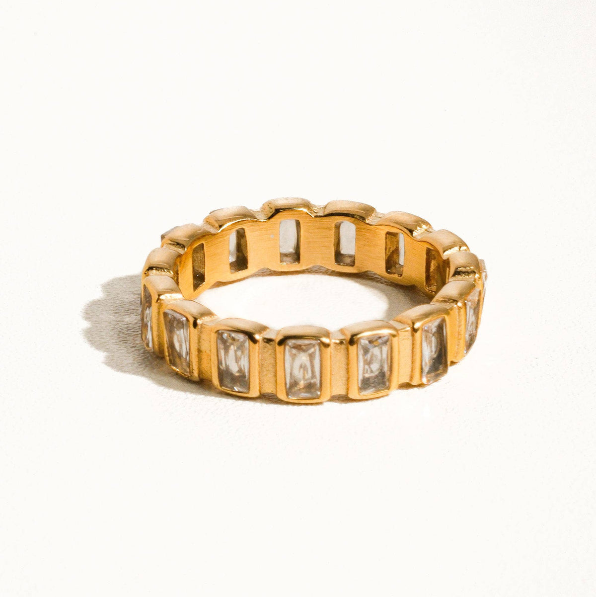 Gold ring with embedded stones on a white background