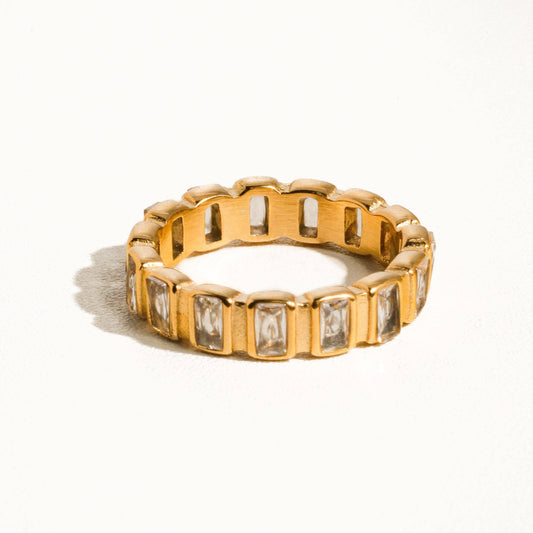 Gold ring with embedded stones on a white background